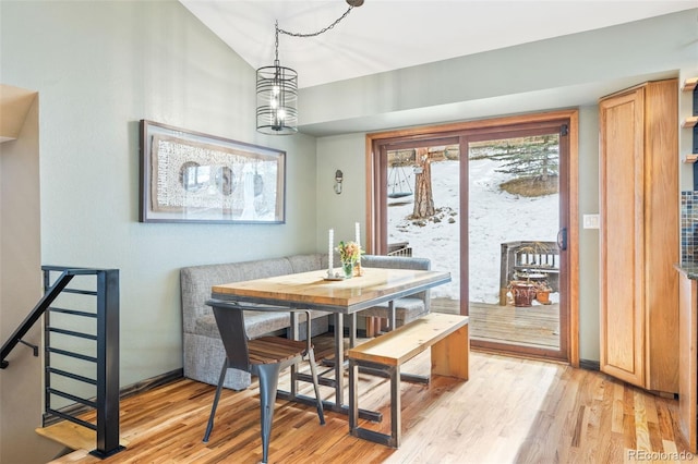 dining space with breakfast area, lofted ceiling, a chandelier, and light hardwood / wood-style flooring