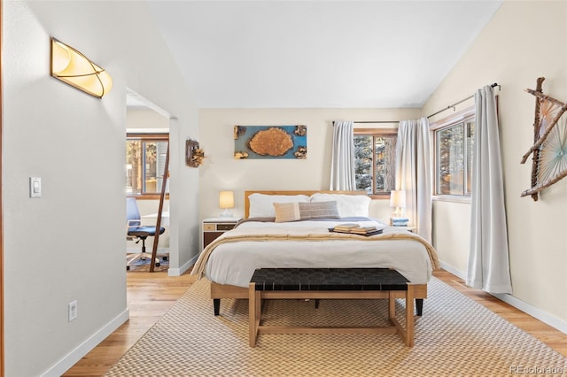 bedroom with vaulted ceiling and light hardwood / wood-style flooring