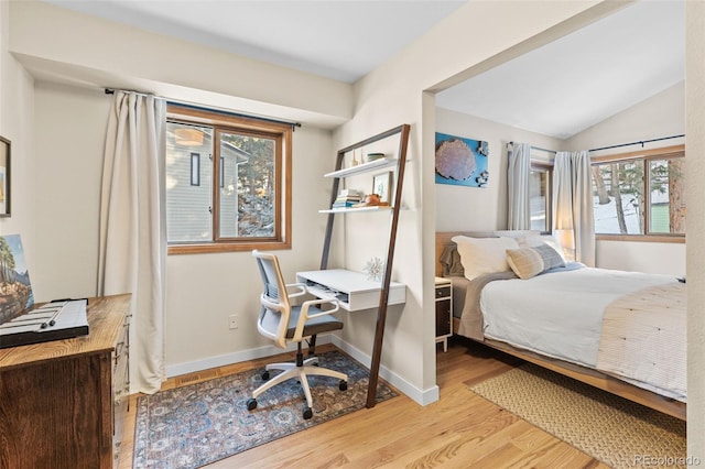 bedroom featuring light hardwood / wood-style flooring and vaulted ceiling