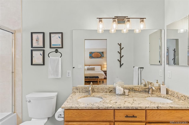 full bathroom featuring vanity, combined bath / shower with glass door, and toilet