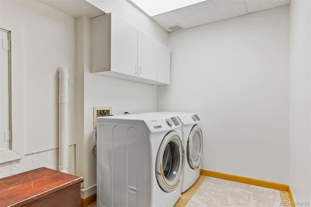 washroom with cabinets and washing machine and clothes dryer