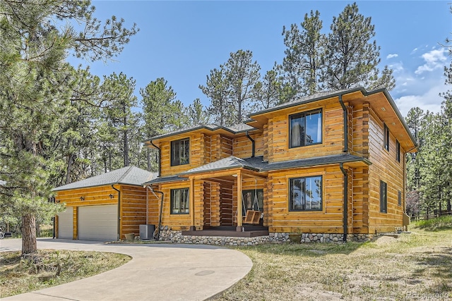 log cabin with cooling unit, a porch, and a garage