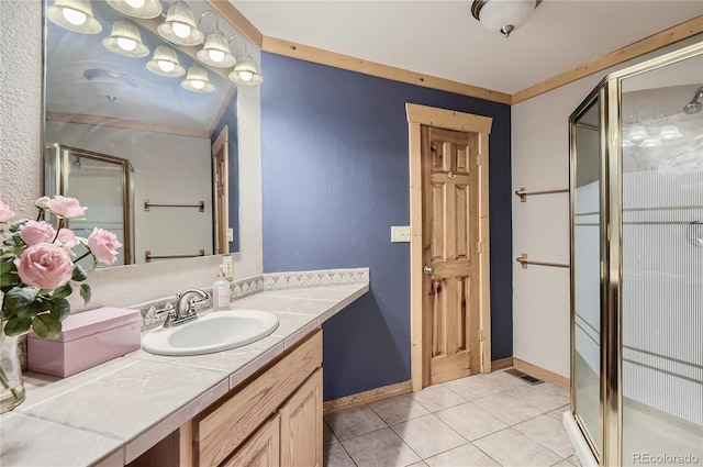 bathroom with vanity, ornamental molding, tile patterned flooring, and walk in shower