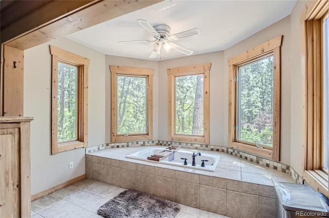 bathroom featuring ceiling fan, a healthy amount of sunlight, tile patterned floors, and a relaxing tiled tub