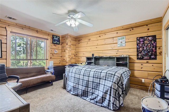 bedroom with ceiling fan, carpet, and wooden walls