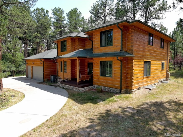 exterior space with a front lawn, a garage, and central AC