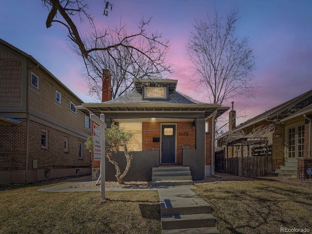 view of front of property with brick siding and a chimney