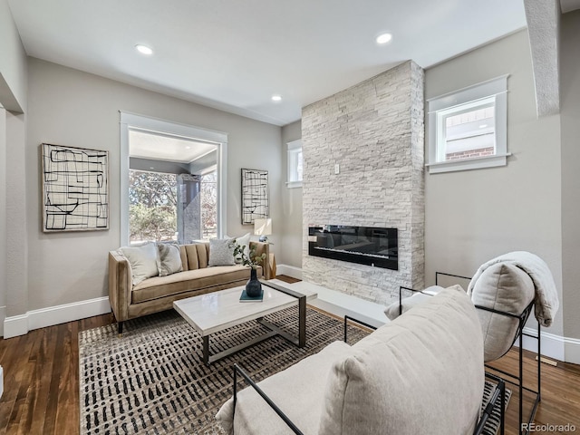 living area with recessed lighting, a fireplace, baseboards, and wood finished floors