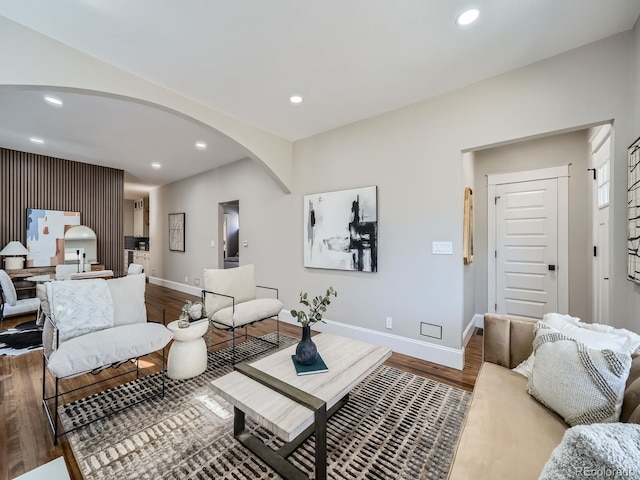 living room with recessed lighting, baseboards, arched walkways, and wood finished floors