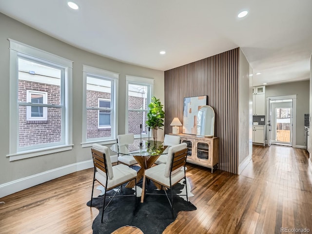 dining room with hardwood / wood-style flooring, recessed lighting, and baseboards