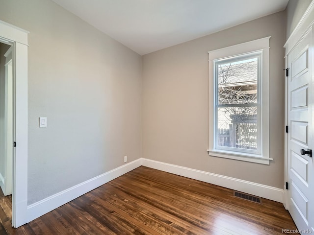 unfurnished bedroom with visible vents, dark wood-type flooring, and baseboards