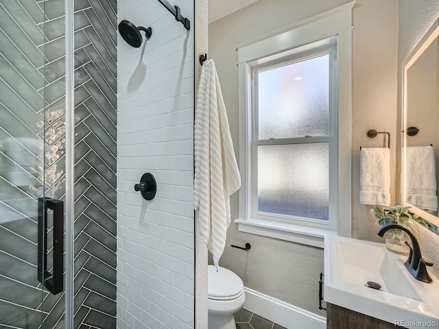 bathroom featuring vanity, baseboards, tile patterned flooring, a shower stall, and toilet