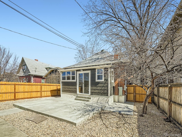 back of house with entry steps, a patio, a gate, and a fenced backyard