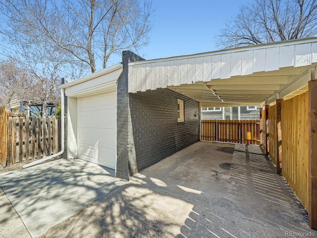 view of vehicle parking with a carport, concrete driveway, and fence