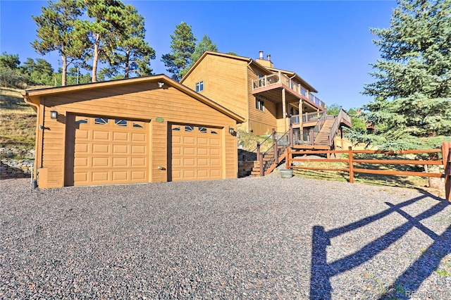 view of front of property with a balcony, an outbuilding, and a garage