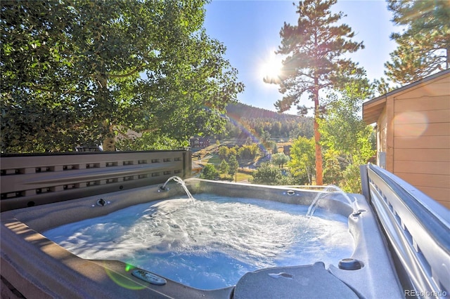 wooden deck featuring a mountain view and a hot tub