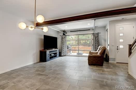 unfurnished living room with beamed ceiling