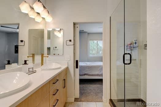 bathroom featuring vanity, a shower with shower door, and tile patterned flooring