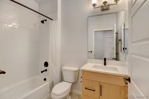 full bathroom featuring vanity, toilet, and shower / bathtub combination with curtain