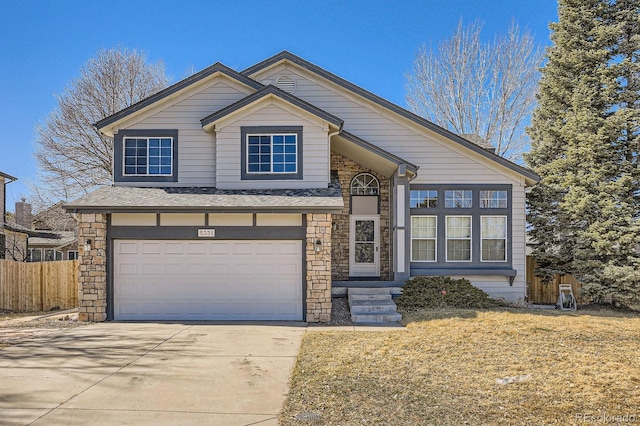 view of front of house with a garage, stone siding, concrete driveway, and fence