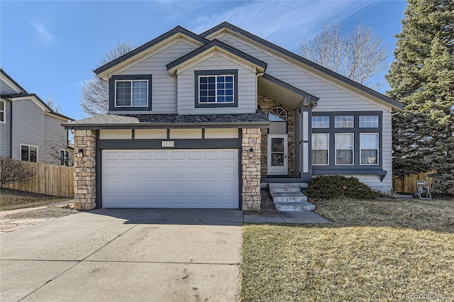 view of front facade with an attached garage, fence, stone siding, and driveway