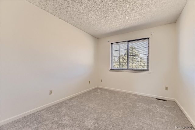 spare room with baseboards, a textured ceiling, and carpet flooring