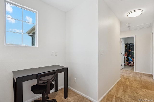 carpeted office space with attic access and baseboards