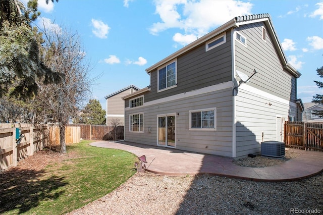 rear view of property with a yard, a patio, central AC, and a fenced backyard