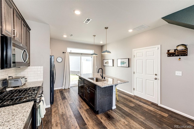 kitchen featuring sink, dark brown cabinets, a center island with sink, and appliances with stainless steel finishes