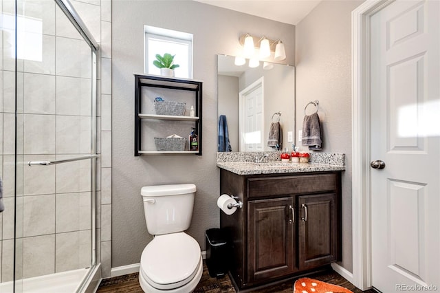 bathroom with hardwood / wood-style flooring, vanity, toilet, and a shower with door