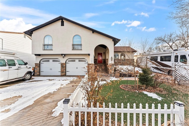 view of front of home featuring a fenced front yard, stone siding, an attached garage, and stucco siding