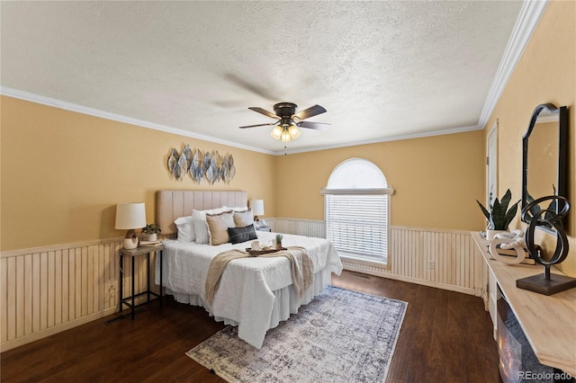 bedroom featuring dark wood-style floors, a wainscoted wall, ceiling fan, and a textured ceiling