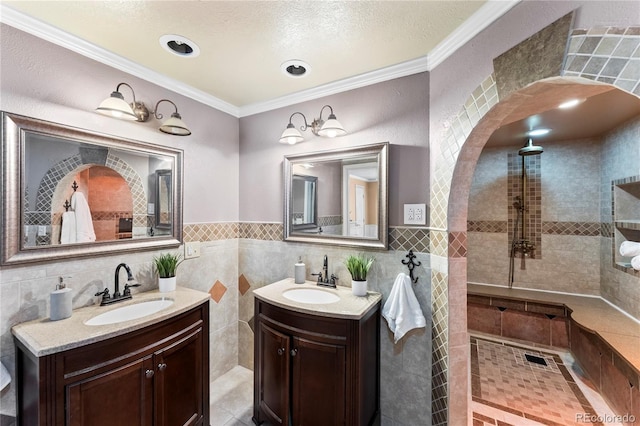 bathroom featuring walk in shower, crown molding, two vanities, and a sink