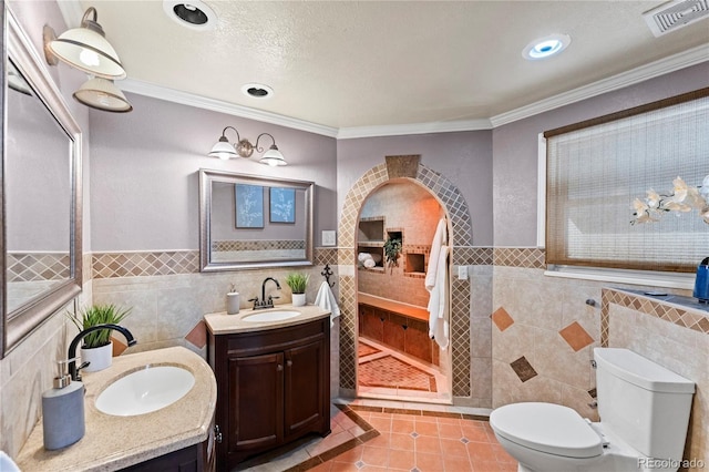 bathroom with tile patterned flooring, visible vents, tile walls, and a sink