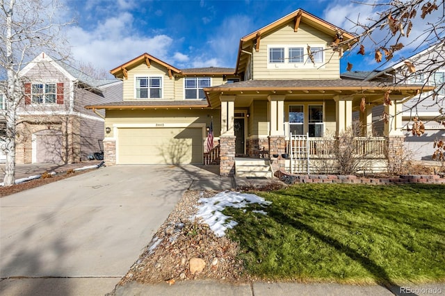 view of front of house with a porch, a front yard, and a garage