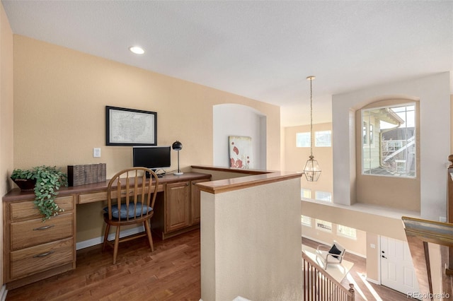 home office featuring built in desk and dark hardwood / wood-style flooring