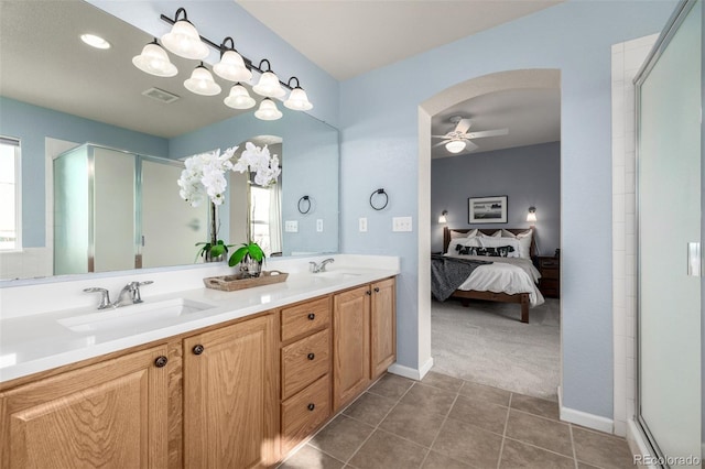 bathroom featuring tile patterned flooring, a shower with door, ceiling fan, and vanity