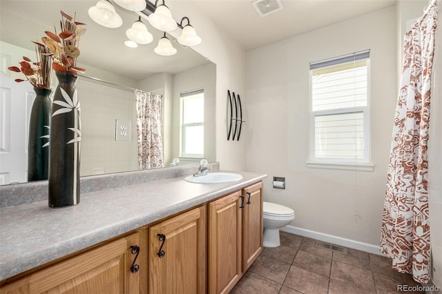 bathroom featuring toilet, tile patterned flooring, vanity, and plenty of natural light