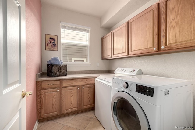 washroom with washer and dryer, cabinets, and light tile patterned flooring