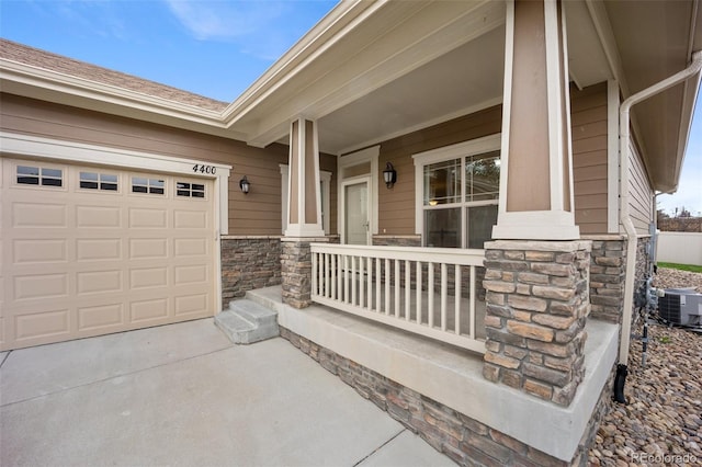 4400 S Ensenada St, Aurora, CO 80015 - entrance to property with stone siding, covered porch, central air condition unit, and driveway