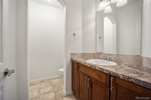 4400 S Ensenada St, Aurora, CO 80015 - bathroom featuring toilet, vanity, tile patterned floors, and baseboards