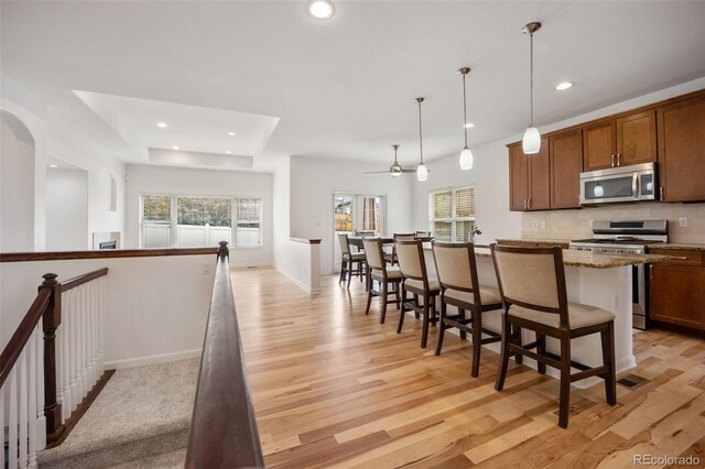 4400 S Ensenada St, Aurora, CO 80015 - kitchen featuring appliances with stainless steel finishes, plenty of natural light, light wood-type flooring, recessed lighting, and a kitchen breakfast bar