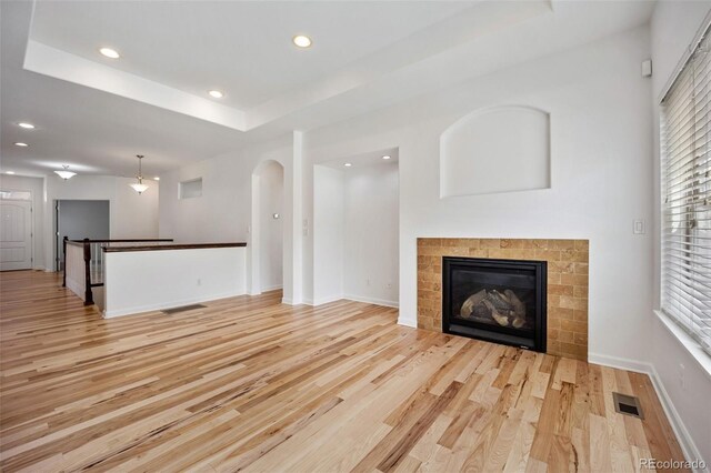 4400 S Ensenada St, Aurora, CO 80015 - unfurnished living room featuring light wood-type flooring, recessed lighting, plenty of natural light, baseboards, and a fireplace