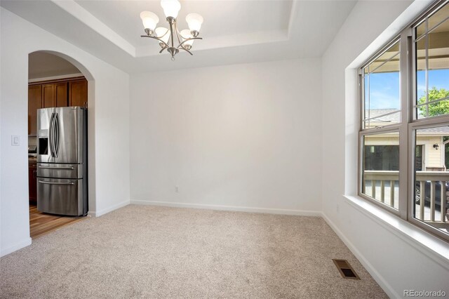 4400 S Ensenada St, Aurora, CO 80015 - empty room with light colored carpet, plenty of natural light, a raised ceiling, and arched walkways