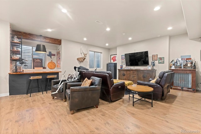 living room featuring light hardwood / wood-style floors, a wealth of natural light, and bar