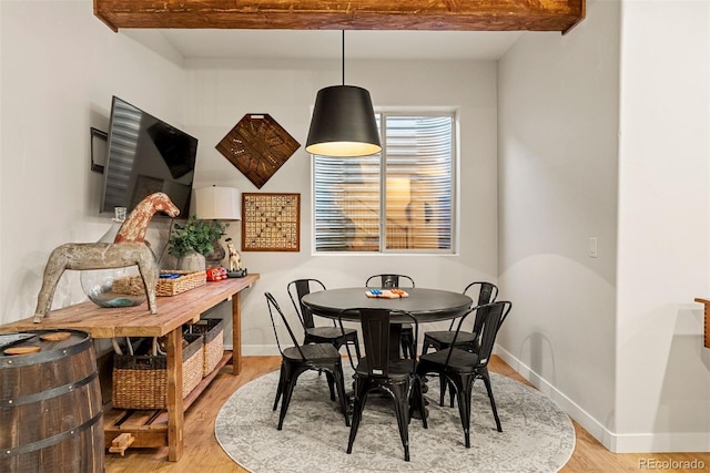 dining space with hardwood / wood-style floors and beamed ceiling