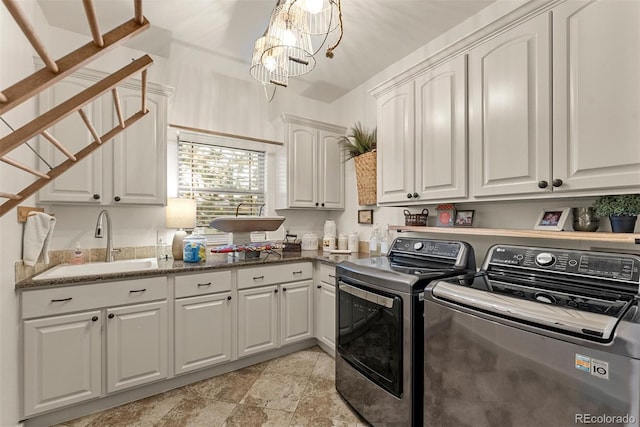 laundry room with washer and dryer, sink, cabinets, and a chandelier