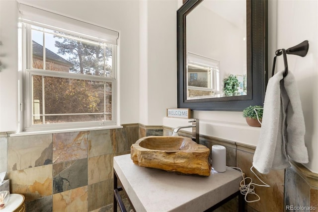 bathroom featuring vanity and tile walls