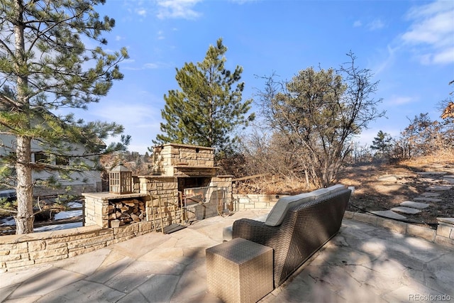 view of patio featuring an outdoor stone fireplace