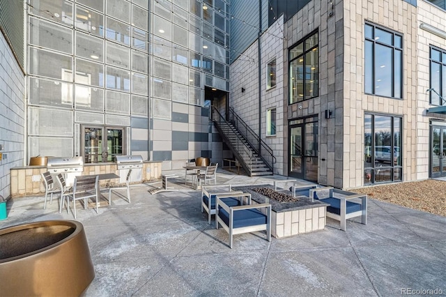 view of patio / terrace with a fire pit, area for grilling, exterior kitchen, and stairs